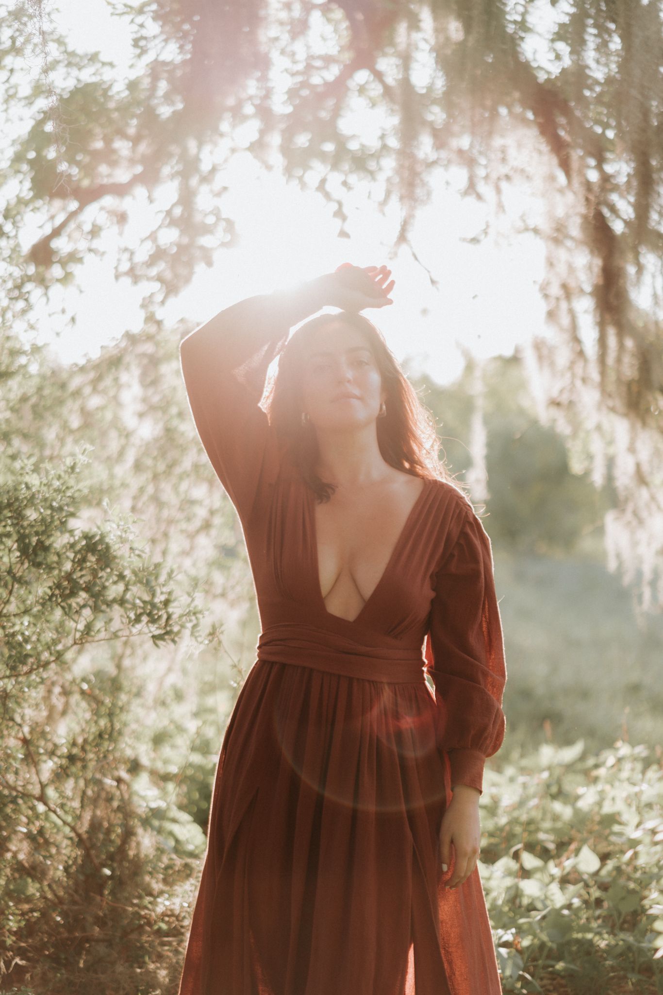 A woman in a wine-red dress bathed in warm sunlight